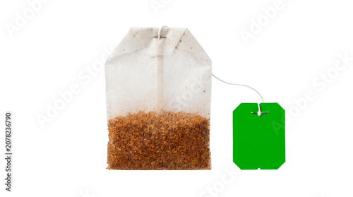 A tea bag filled with loose brown tea leaves on a white surface