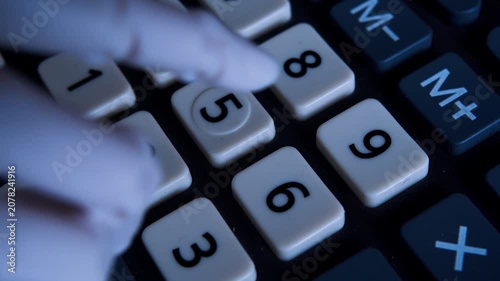 POV macro of an AI robotic hand pressing buttons on an office calculator. 