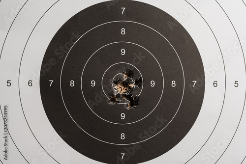 Φωτογραφία Close up view of a paper shooting target with a tight group of bullet holes exactly in the bulls-eye ten score ring, concept of sniper precision and perfect accuracy