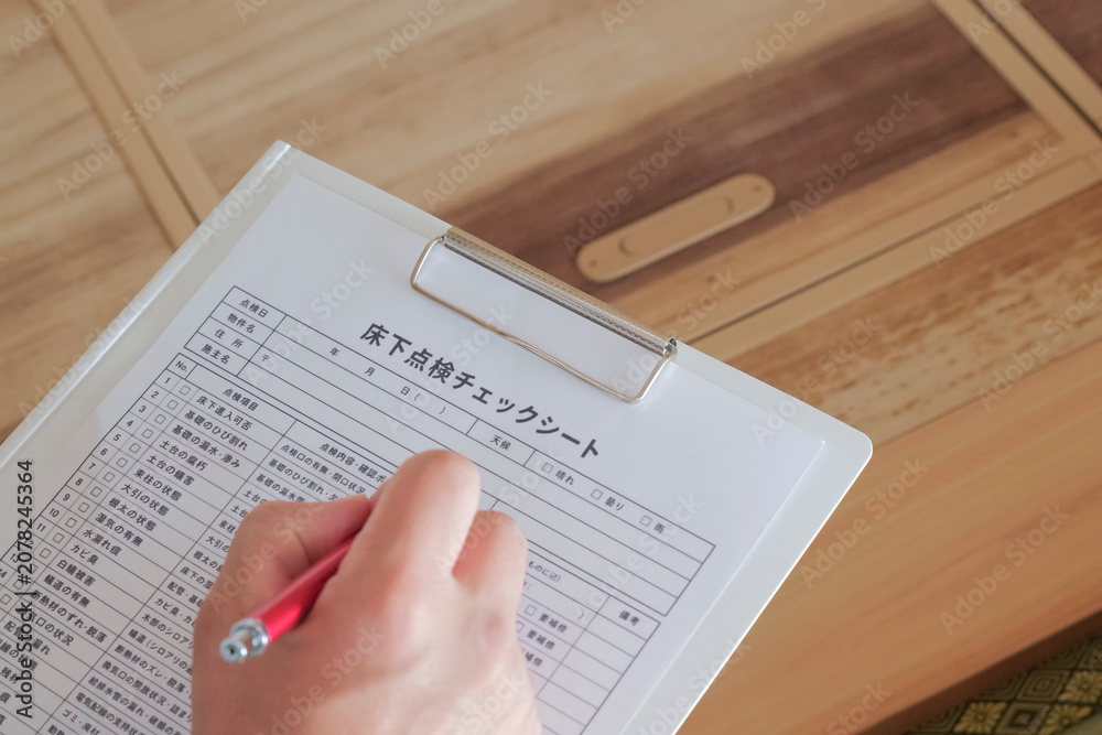 Obraz premium 床下点検口から床下を確認 する作業員