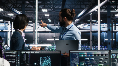 Принти на полотні IT colleagues collaborate in a data center while reviewing AI diagnostics and infrastructure performance