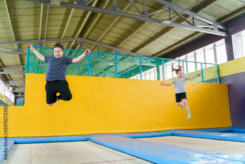 Photography Happy smiling small kids jumping on indoors trampoline in entertainment center