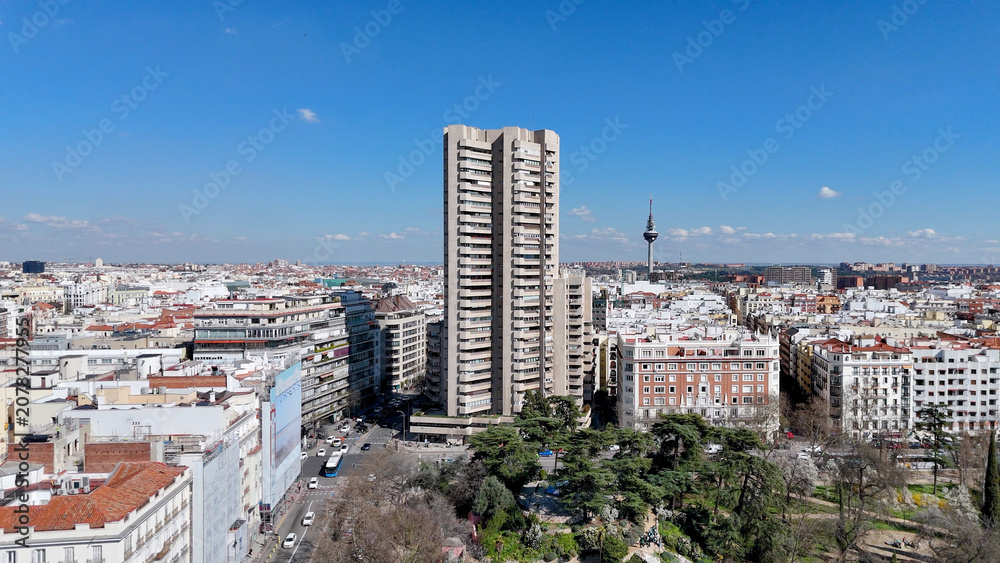Fototapeta premium High-resolution drone photograph showcasing Madrid's skyline with residential neighborhoods, modern high-rise architecture and a bright blue sky filled with scattered clouds