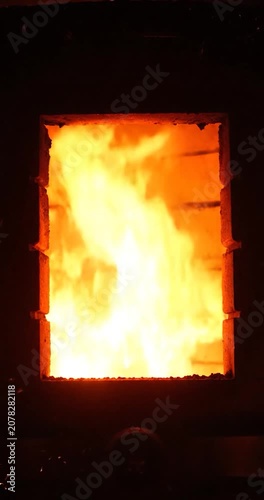 Intense Fire Burning Inside A Dark Industrial Furnace Heating Chamber