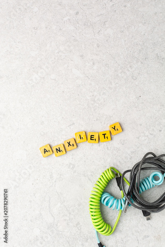 Top view of assorted charging cables surrounding wooden letter tiles spelling 