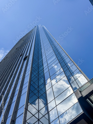 Modern skyscraper reflecting clouds on a sunny day