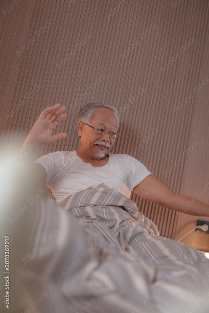 Obraz premium Aged care: Older Asian gentleman asleep in a comfortable hospital bed, breathing slowly as he rests and heals in a warm quiet recovery room, tender everyday care