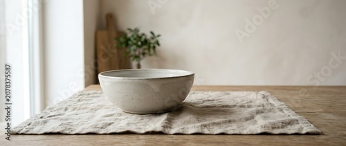white ceramic bowl on linen napkin on wooden table in minimalist kitchen