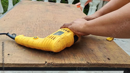 Hand inserting a metal drill bit into an electric cordless drill
