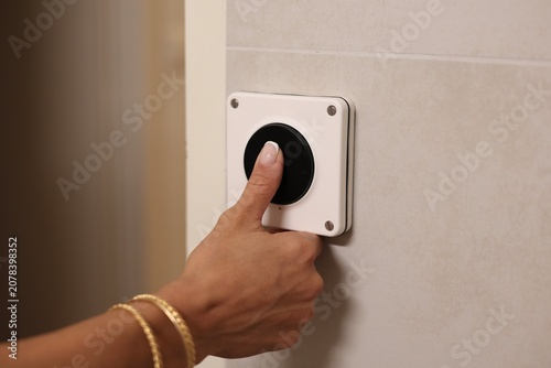 Cuadro en lienzo Main de femme appuyant sur un interrupteur étanche de salle de bain