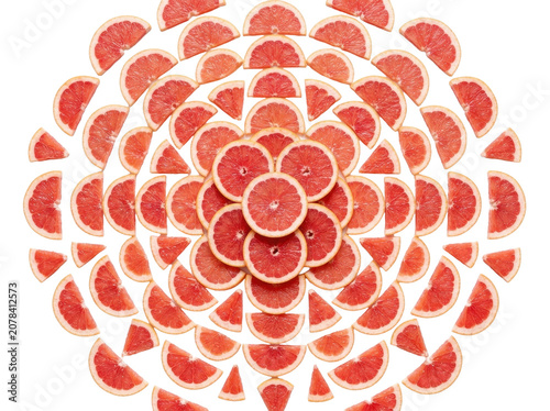 Vibrant grapefruit slices arranged in a circular pattern on a white background
