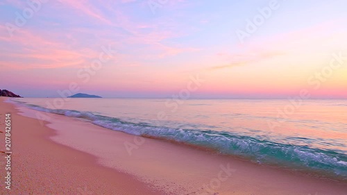 Breathtaking Tropical Beach Sunset with Soft Pastel Pink and Blue Sky Reflecting over Calm Ocean Waves at Twilight