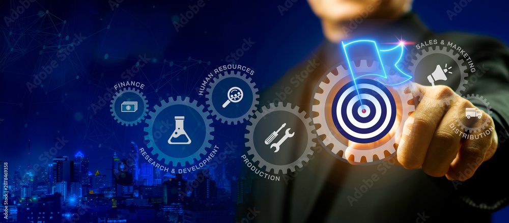 Fototapeta premium Businessman pointing at glowing gear with target flag icon. Milestone achievement, business objective and success concept.