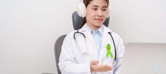 doctor using laptop for telehealth, online consultation and meeting about lime Green Ribbon for concept of May Celiac Awareness month, Lyme disease, September Lymphoma, Mental Health