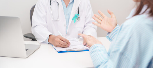 Doctor and patient having a medical consultation for Teal ribbon concept of September Ovarian Cancer Awareness month, PCOS, January Cervical Cancer, April Sexual Assault, June PSTD