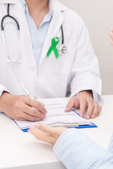 Doctor and patient having a medical consultation for lime Green Ribbon for concept of May Celiac Awareness month, Lyme disease, September Lymphoma, Mental Health Awareness month and Liver cancer
