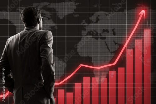 Businessman analyzing glowing red stock market growth graph with world map on dark background for financial investment marketing
