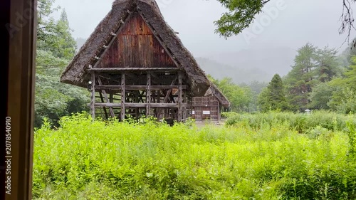Camera moving from inside a traditional Japanese house to misty Shirakawa-go village, Japan