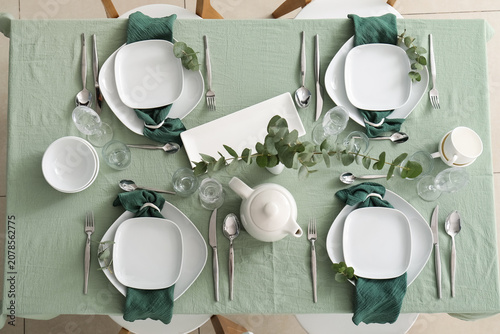 Photos Elegant dining table set with green napkins and white dishes