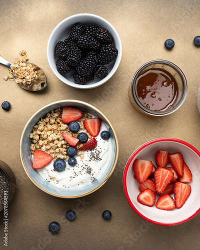 Homemade yogurt parfait with granola fresh berries honey and chia seeds top view