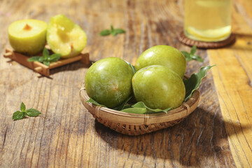 Fresh Green Plums in Wicker Basket on Wooden Table Studio Food Photography