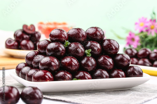 Foto Fresh Dark Red Cherries on White Plate with Water Droplets