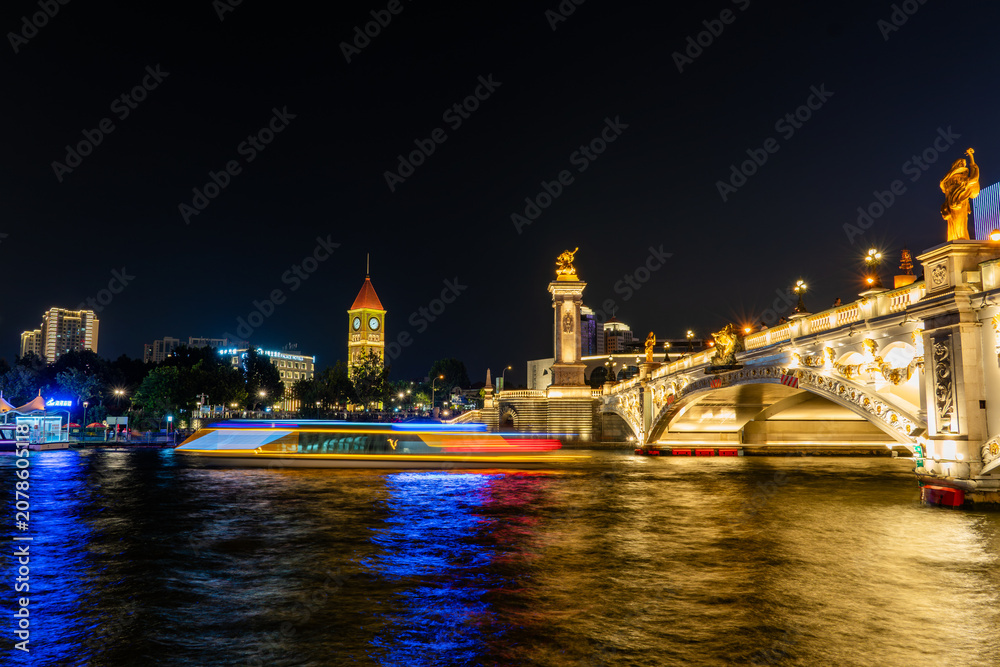 Naklejka premium Historic Bridge and River at Night with Illuminated Monuments