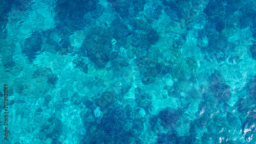 The  blue crystal clear water background for summer vacation concept. Beach nature and summer seawater with sunlight light  beach Sparkling sea water