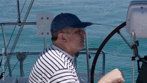 Experienced sailor helming a sailboat at sea