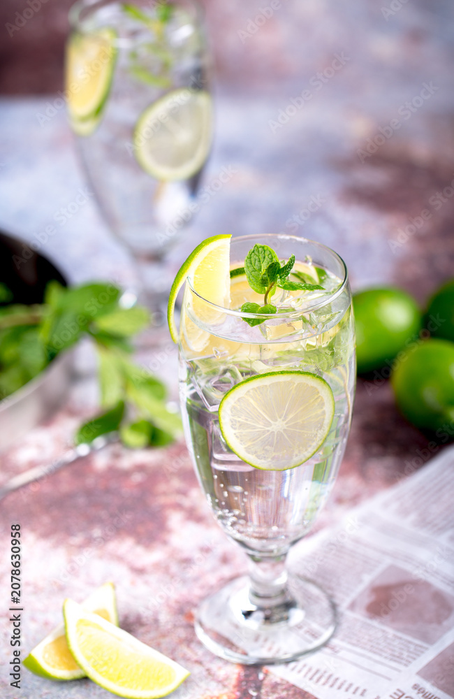 Fototapeta premium Refreshing lime and lemon drink with mint and ice in tall glasses