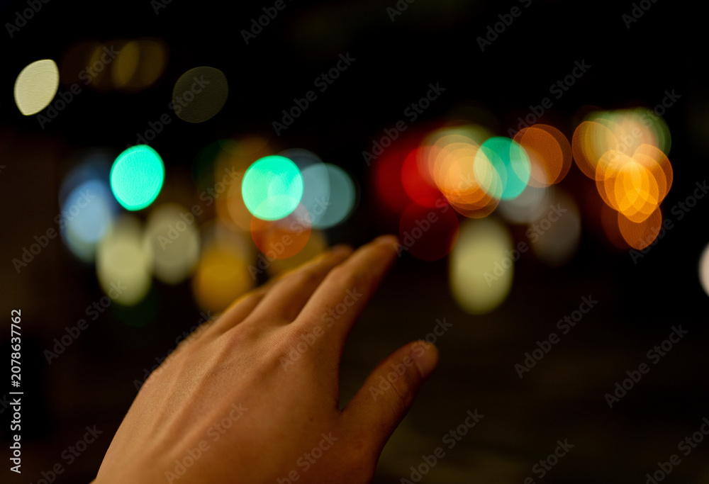 Fototapeta premium abstract scene of hand touching Christmas lights