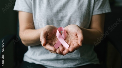 Woman holding pink breast cancer awareness ribbon