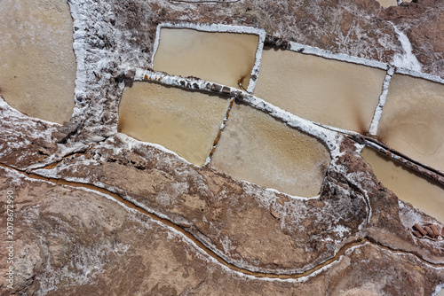 Fotografie Aerial view of Maras salt ponds with white edges in Andean rock