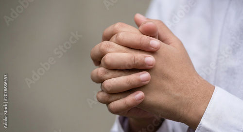 Close Up of Clasped Hands Resting Over White Long Sleeve Shirt