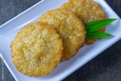 Bild auf Leinwand Kue cucur gula merah served elegantly with aromatic pandan leaf on a ceramic pla