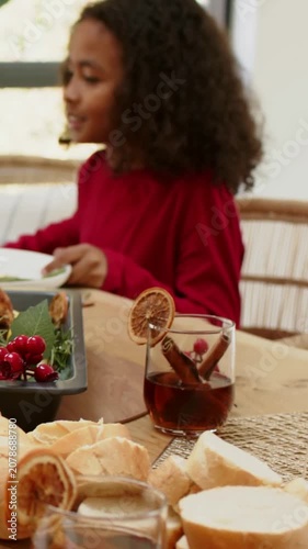 Vertical video: Leaning child red top angling plate as adult serving roast at home, copy space