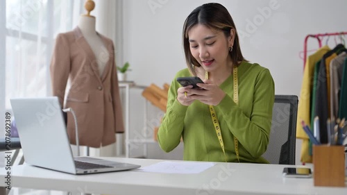 Asian female fashion designer working in her office