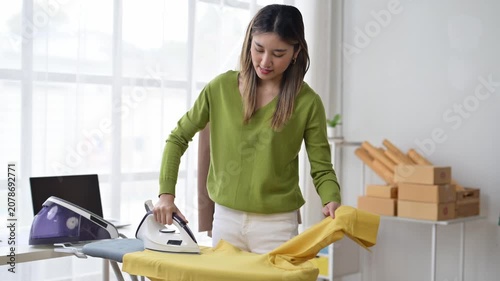 Online seller ironing clothes before shipping