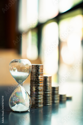 Hourglass with stacked coins growing background for long term financial investment plan concept, time value of money, wealth management, retirement saving analysis, compound interest rate.