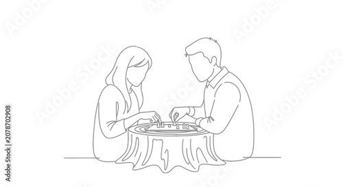 Two people sitting at a table with a laptop.