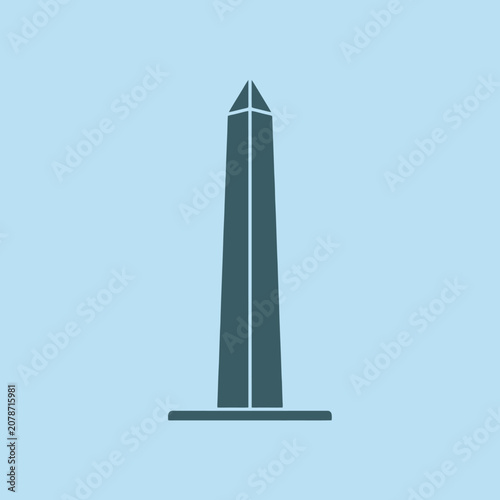 A dark grey obelisk stands on a light blue background