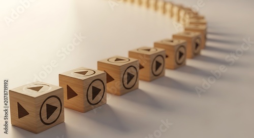 A row of wooden play buttons on cubes in a curved line on a beige surface
