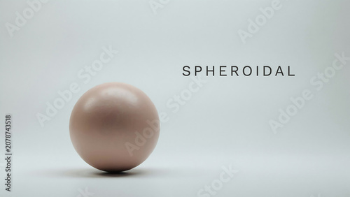 A large pink sphere sitting on a plain surface with the word SPHEROIDAL written in black text to its right on a white background