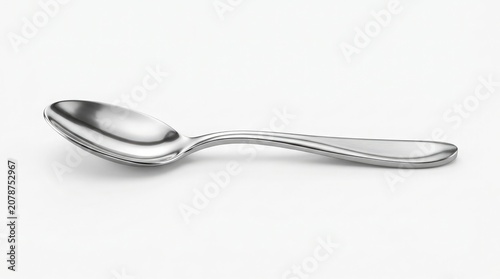 A shiny metal spoon on a clean white surface with no background distractions indoors