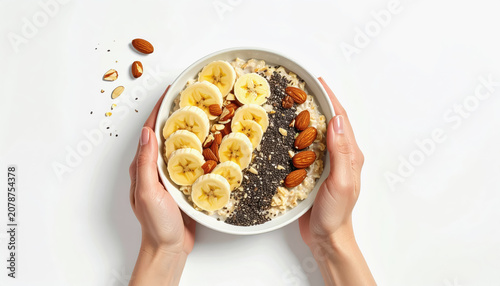 Hands Holding Bowl of Oatmeal with Bananas, Almonds, and Chia Seeds