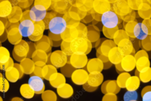 Golden yellow abstract bokeh lights background with soft blue circles for celebration festive wallpaper