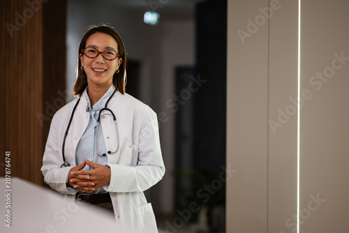 Obraz na płótnie Asian doctor woman smiling at medical clinic