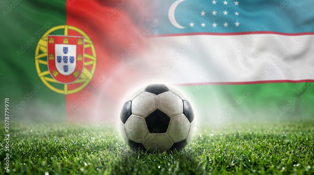 Naklejka premium Portugal vs Uzbekistan Flags and Soccer Ball: A soccer ball rests on green grass with the flags of Portugal and Uzbekistan waving in the background, symbolizing an international match or sports event.