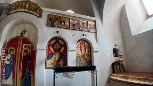 Vardzia, Georgia, May 1, 2025: Detailed iconostasis inside a rock-hewn monastery church, featuring religious icons and fresco elements of Georgian Orthodox tradition