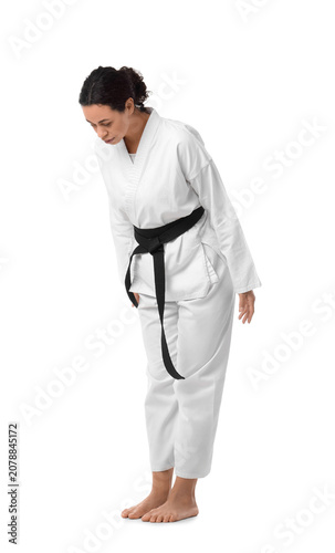 Young African-American woman practicing karate on white background